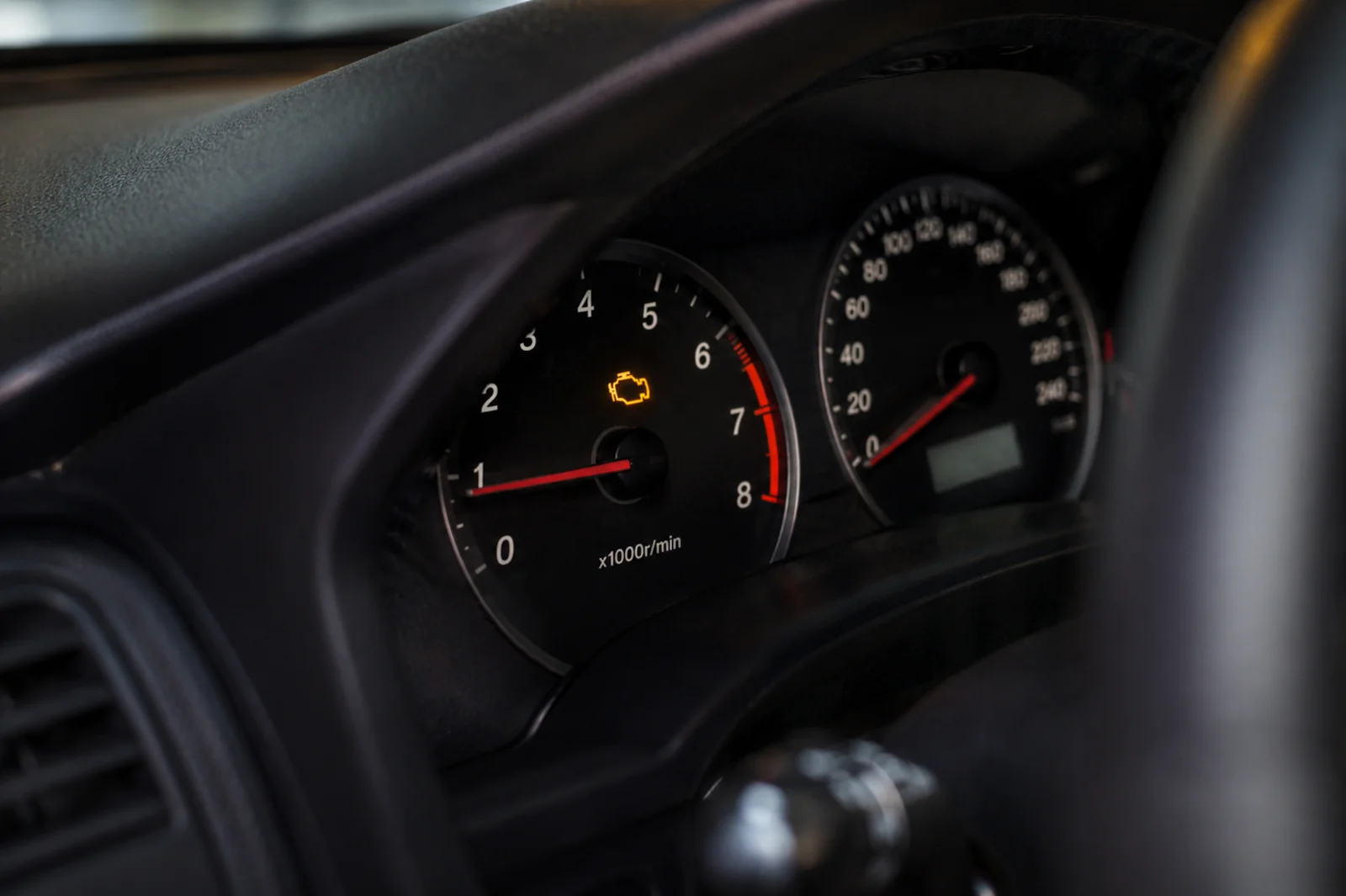 Żółta kontrolka check engine świecąca na desce rozdzielczej samochodu