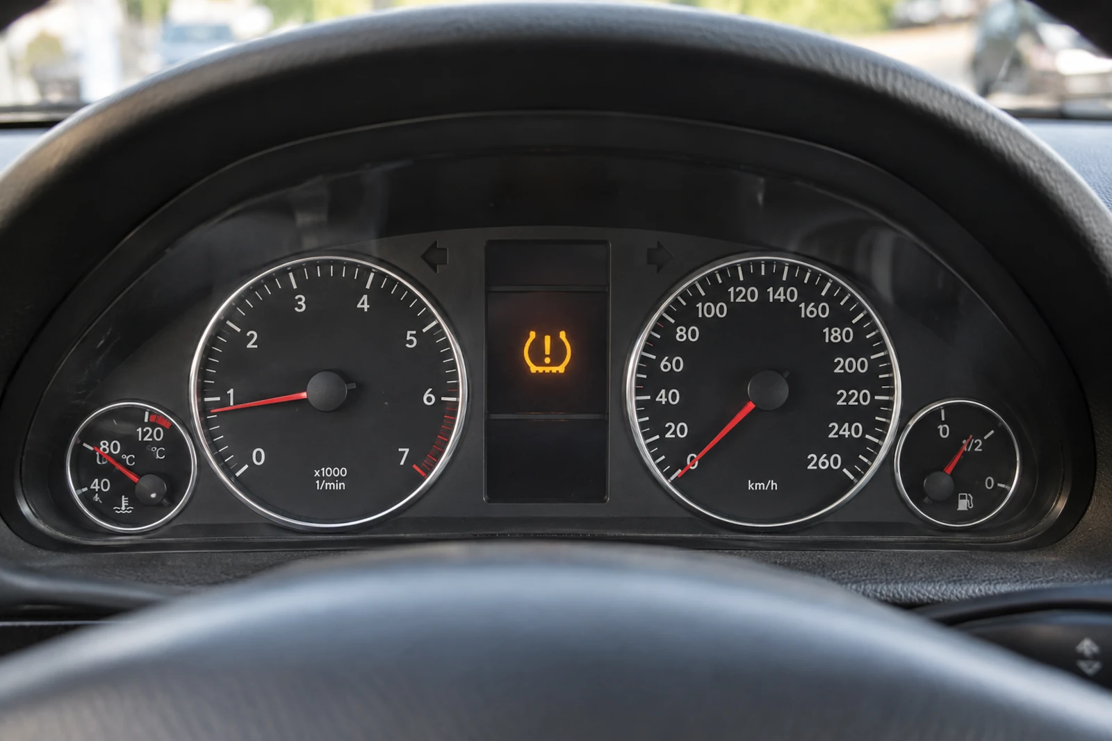 Świecąca kontrolka TPMS pomiędzy zegarami na desce rozdzielczej samochodu.